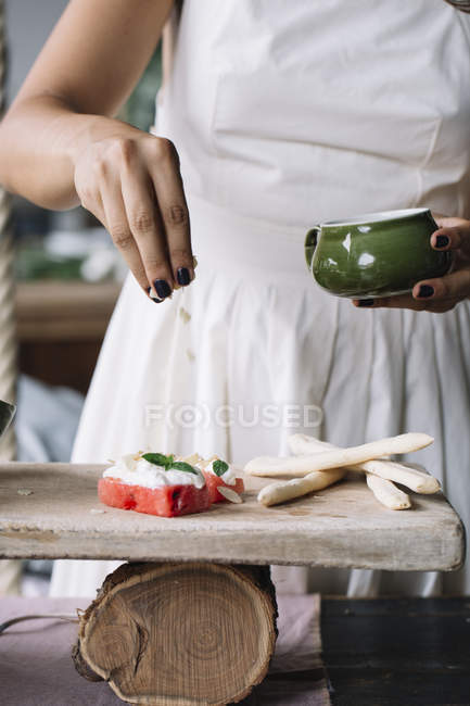 Mulher preparando prato vegetariano na tábua de corte — Fotografia de Stock