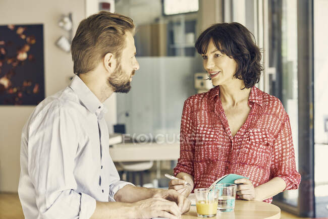 Homme d'affaires et femme d'affaires se réunissant dans une aire de repos — Photo de stock