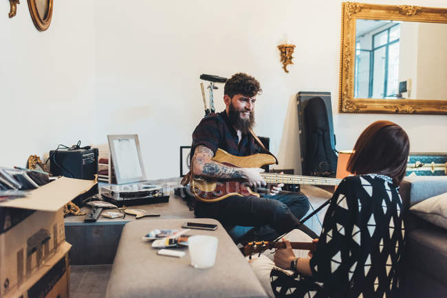 Casal tocando guitarras elétricas no apartamento — Fotografia de Stock