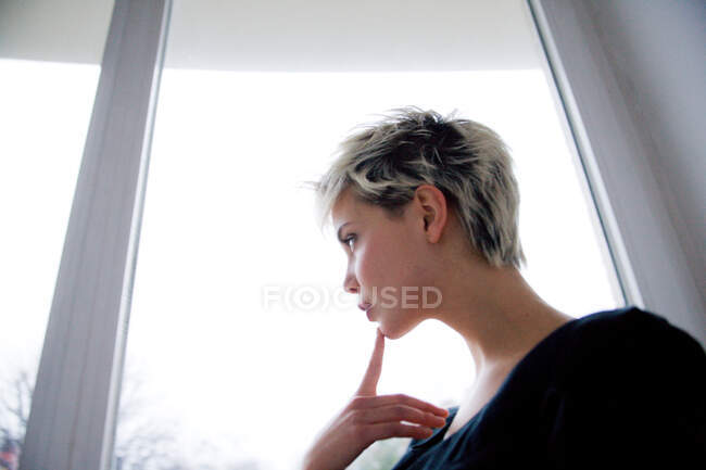 Girl looking out the window — Stock Photo