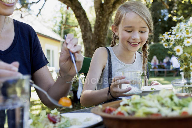 Mother and daughter having lunch in garden — Stock Photo