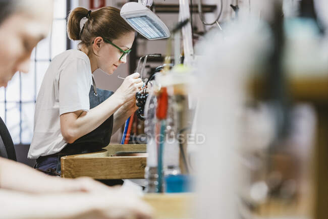 Female and male jewellers at workbench — Stock Photo