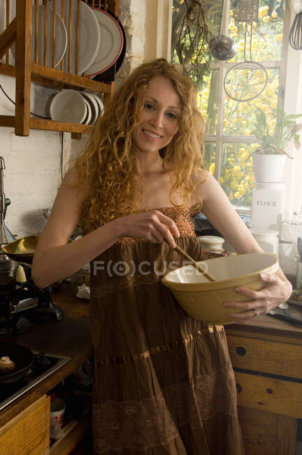 Mulher misturando ingredientes na cozinha — Fotografia de Stock