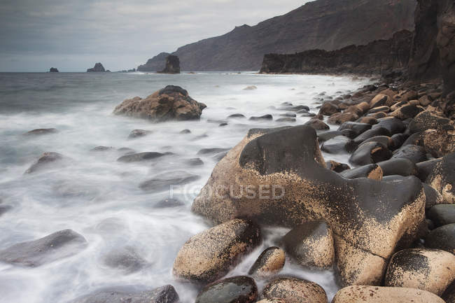 Beautiful natural view with waves washing over rocks on beach — Stock Photo
