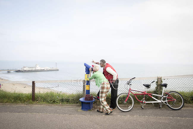 Pareja extraña usando visor de torres, Bournemouth, Inglaterra - foto de stock