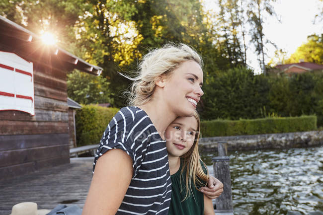 Mother and daughter enjoying themselves by water — Stock Photo