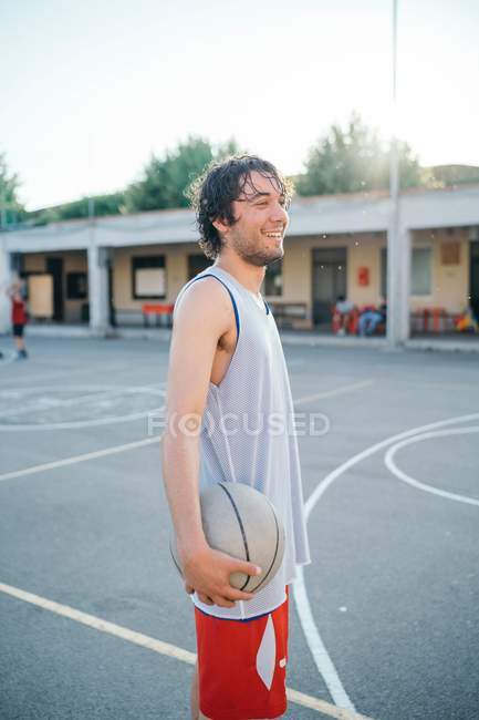 Retrato de jovem com bola na quadra de basquete — Fotografia de Stock