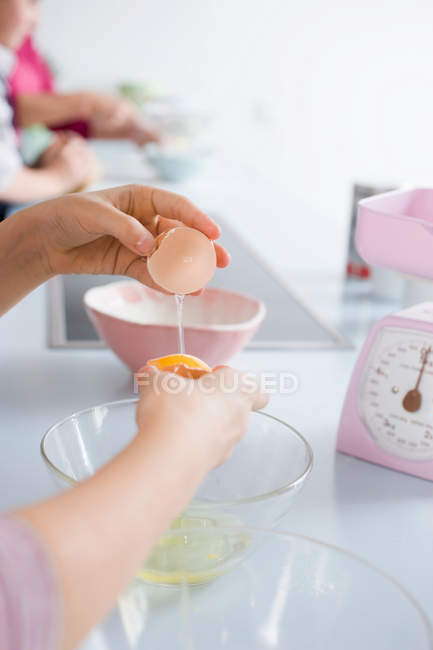 Menina separando gema de ovo e ovo branco, tiro cortado — Fotografia de Stock