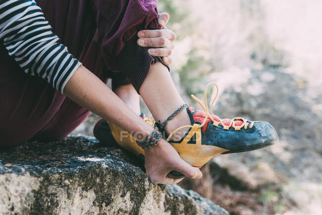 Waist down of female boulderer putting on climbing shoe, Lombardy, Italy — Stock Photo