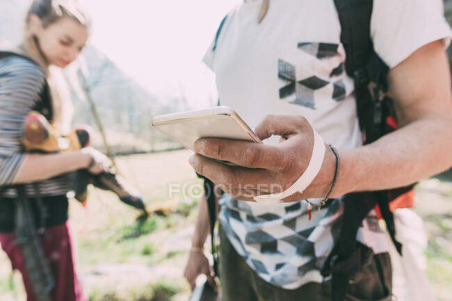 Hand of male boulderer holding smartphone, Lombardy, Italy — Stock Photo