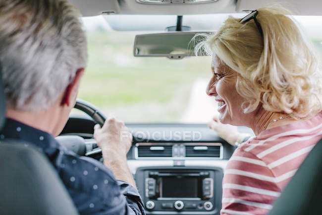 Rear view of happy tourist couple driving car — Stock Photo