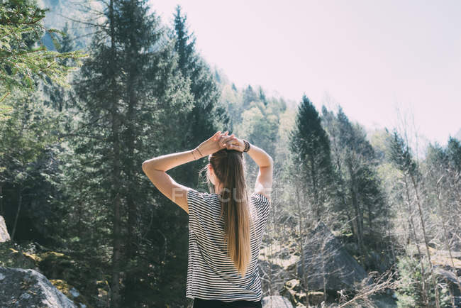 Visão traseira da jovem mulher olhando para a floresta — Fotografia de Stock