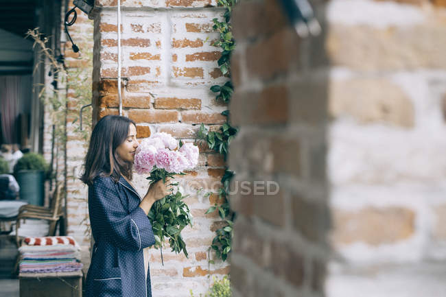 Woman smelling bunch of flowers — Stock Photo