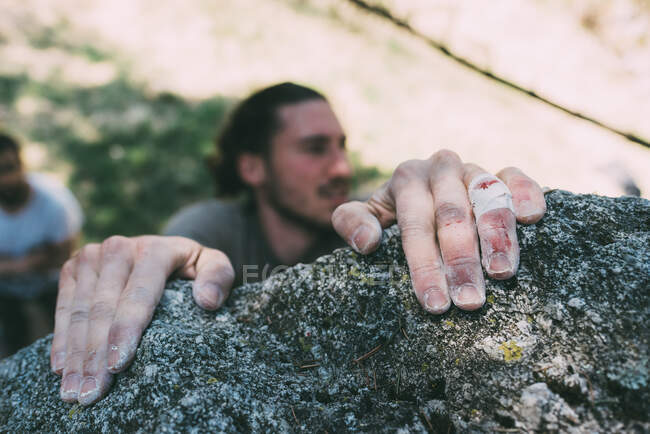 Manos del hombre que agarra el borde de la roca, Lombardía, Italia - foto de stock
