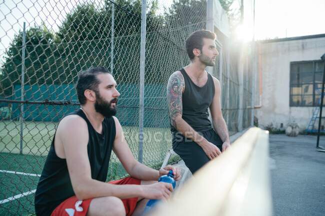 Friends sitting by sports court — Stock Photo