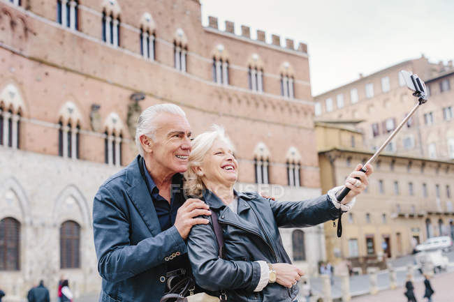 Coppia turistica che utilizza selfie stick in città, Siena, Toscana, Italia — Foto stock
