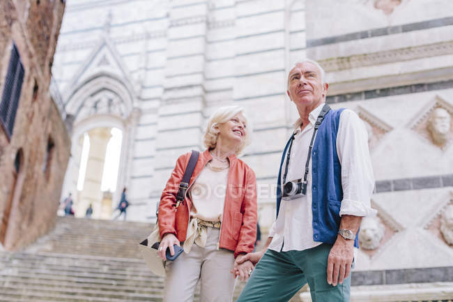 Туристическая пара с камерой и смартфоном по городской лестнице, Сиена, Тоскана, Италия — стоковое фото