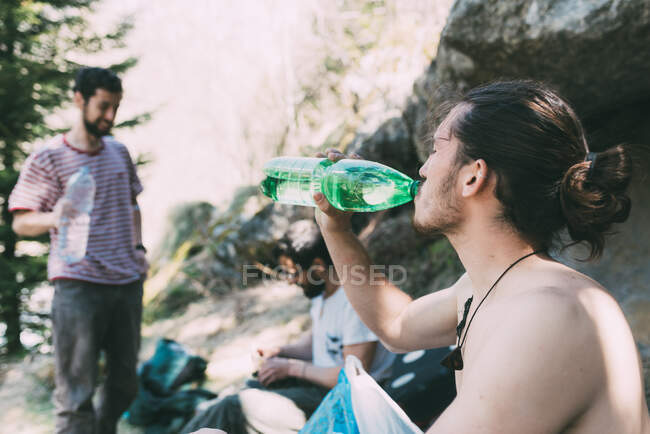 Male boulderers taking a break drinking water, Lombardy, Italy — Stock Photo
