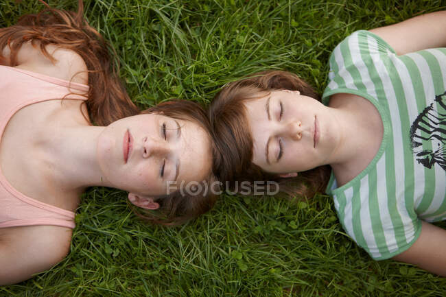 2 girls relaxing together in a park — Stock Photo