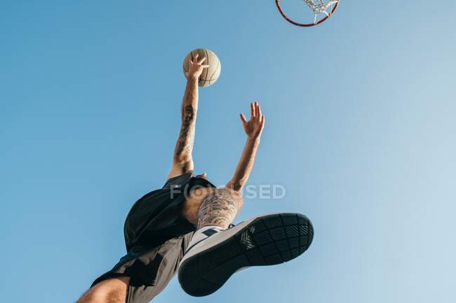 Vue à angle bas du joueur de basket-ball avec basket — Photo de stock