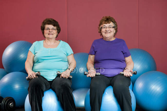 Older women lifting weights in gym — Stock Photo
