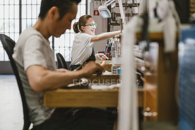 Male and female jewellers working at workbench — Stock Photo