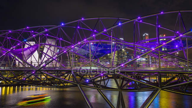Cityscape com ponte hélice roxa sobre Marina Bay à noite, Singapura, Sudeste Asiático — Fotografia de Stock