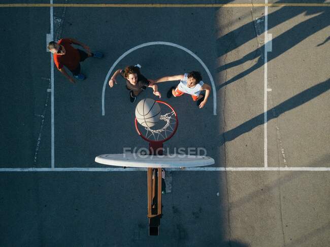 Вид сверху на друзей на баскетбольной площадке, играющих в баскетбол — стоковое фото