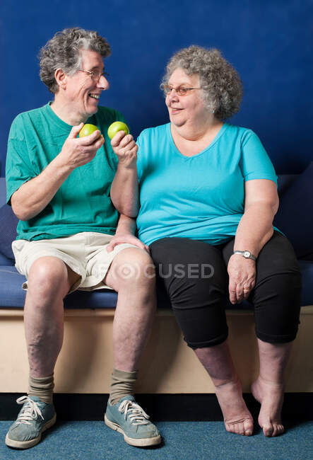 Casal mais velho comendo maçãs juntos — Fotografia de Stock