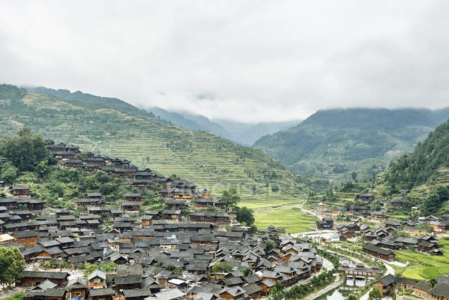 Montaña valle paisaje y pueblo Xijiang, Guizhou, China - foto de stock