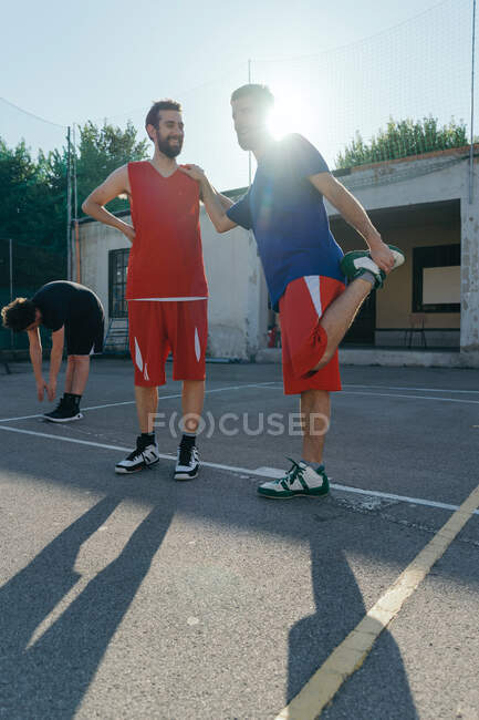 Amigos no campo de basquete aquecendo — Fotografia de Stock