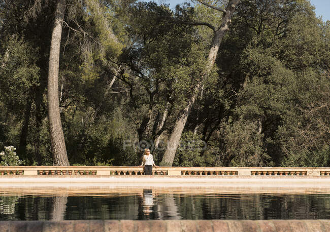 Female tourist looking sideways by lake in Labyrinth Park of Horta, Barcelona, Spain — Stock Photo