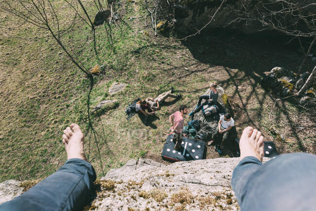 High angle perspective of boulderer above friends on boulder, Lombardy, Italy — Stock Photo