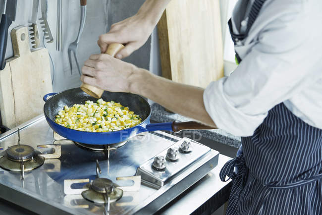Abgeschnittenes Bild vom Koch, der Gemüse in der Pfanne würzt — Stockfoto