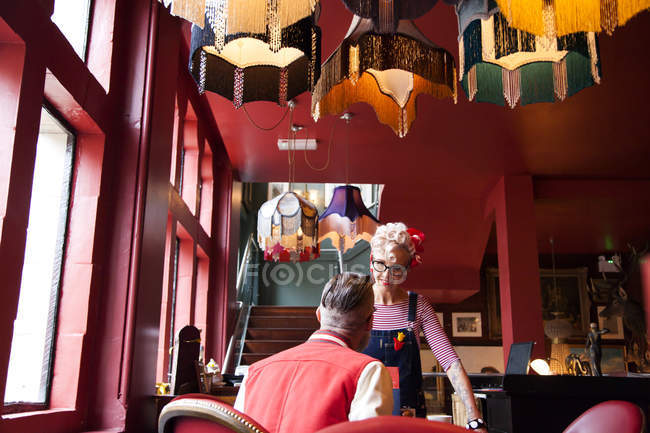 Pareja extraña relajándose en el bar y restaurante, Bournemouth, Inglaterra - foto de stock