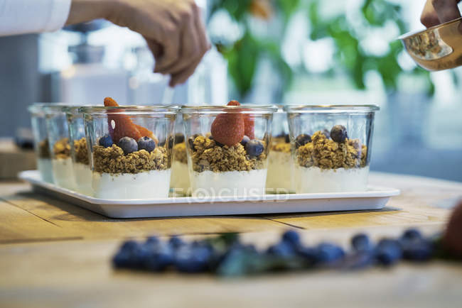 Imagem recortada de Chefs preparando sobremesas com mirtilos e morangos — Fotografia de Stock
