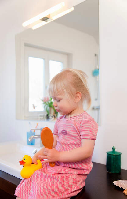 Toddler girl playing with rubber ducks — Stock Photo