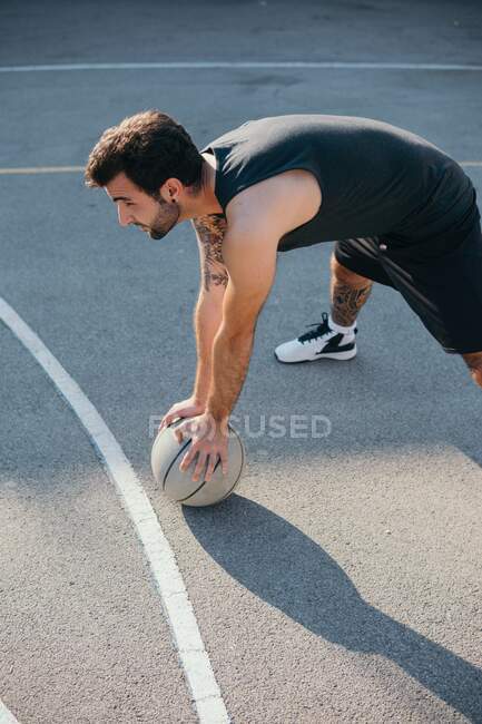 Uomo sul campo da basket con pallacanestro — Foto stock