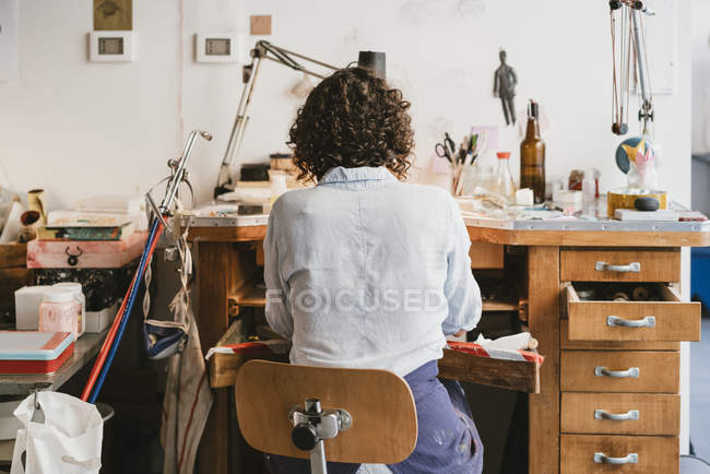 Вид ззаду жіночого ювеліра, що працює на верстаті — стокове фото