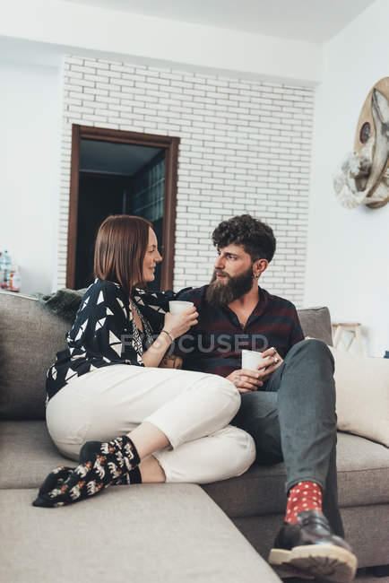Casal relaxante com café no sofá — Fotografia de Stock