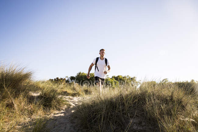 Young man walking on sand dunes — Stock Photo