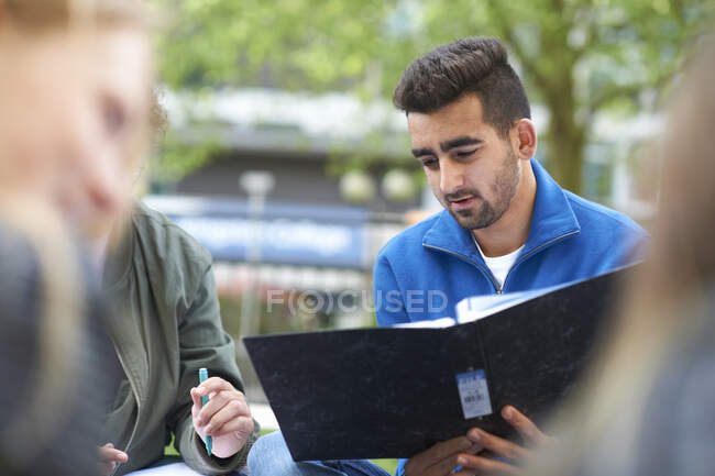 Estudiantes sentados afuera estudiando - foto de stock