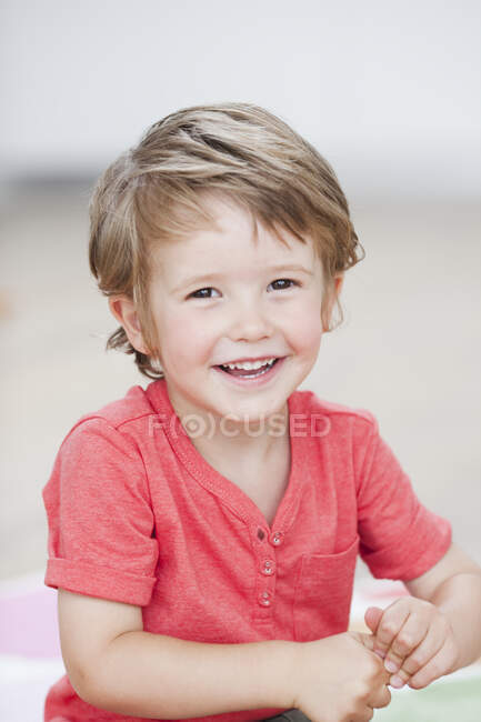 Joven niño sonriendo al espectador - foto de stock