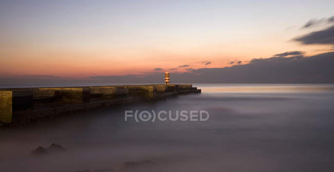Malerischer Blick auf den Leuchtturm bei schönem Sonnenuntergang und Meereslandschaft — Stockfoto