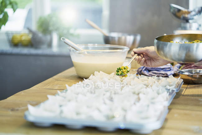 Immagine ritagliata dello chef che aggiunge verdure negli stampi da pasticceria fillo — Foto stock
