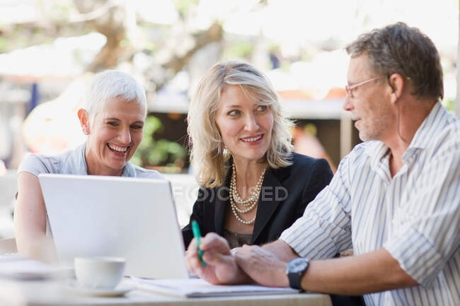 Business people using laptop outdoors — Stock Photo