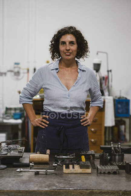 Portrait of mid adult female jeweller in jewellery workshop — Stock Photo