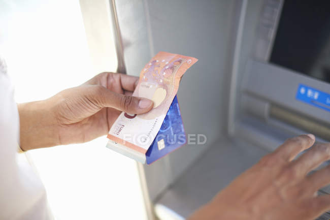 Mulher usando dispensador de dinheiro — Fotografia de Stock