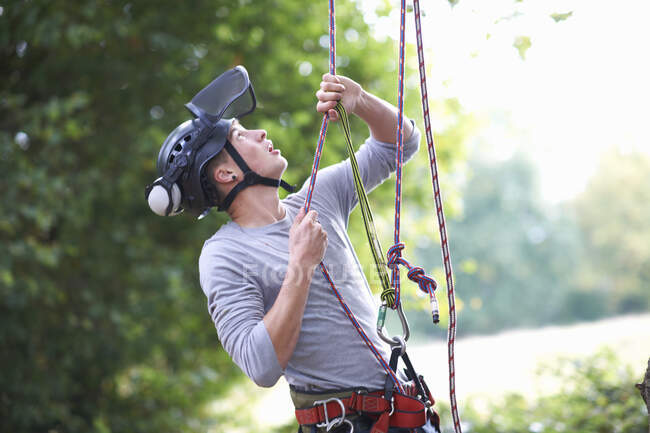 Young male trainee tree surgeon testing climbing ropes — Stock Photo