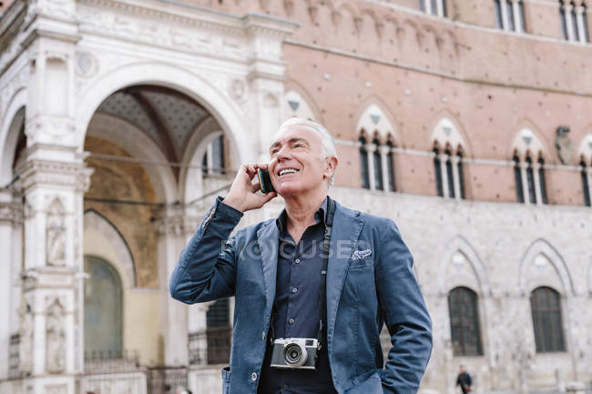 Senior man talking on smartphone in city, Siena, Tuscany, Italy — Stock Photo